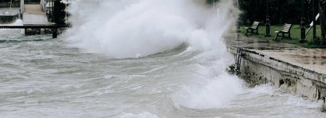 Waves crashing near benches representing climate change 