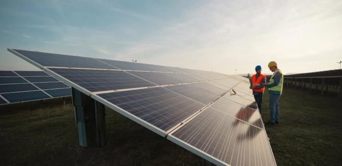 Workers on site examining solar panels